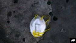 A face mask is discarded on a sidewalk during the coronavirus outbreak in Los Angeles, May 21, 2020.