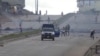 Des manifestants jettent des pierres sur un véhicule de la police anti-émeute sur une route principale du district de Sonfonia à Conakry, en Guinée, le 14 octobre 2019, sur cette image fixe tirée d'une vidéo. Reuters TV / via REUTERS