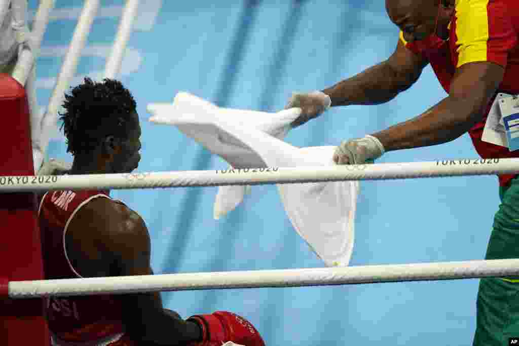 Cameroon's Albert Mengue Ayissi, left, sits in his corner during a timeout in a men's welterweight 69-kg boxing match against Switzerland's Thabiso Dlamini at the 2020 Summer Olympics, Saturday, July 24, 2021, in Tokyo, Japan. (AP Photo/David Goldman)