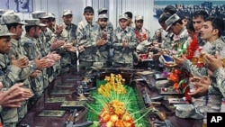 Afghan newly graduated border police officers clap after taking the oath during a graduation ceremony at the border police headquarters in Jalalabad, Nangarhar province, east of Kabul, Afghanistan, January 31, 2012.