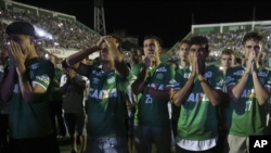 Chapecoense soccer players who did not travel with their team on a flight to Colombia, mourn during a tribute with fans to their late teammates in Chapeco, Brazil, Nov. 30, 2016. 