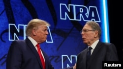 Колишній президент США Дональд Трамп вітає керівника NRA Вейна ЛаП'єра під час конференції в Г'юстоні, 27 травня 2022 року. REUTERS/Шеннон Стейплтон