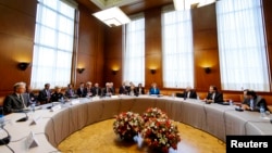 Delegations from Iran and other world powers sit before the start of two days of closed-door nuclear talks at the United Nations offices in Geneva, Switzerland, Oct. 15, 2013. 