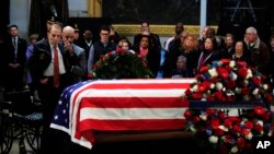 Former Sen. Bob Dole salutes the flag-draped casket containing the remains of former President George H.W. Bush as he lies in state at the U.S. Capitol in Washington, Dec. 4, 2018.