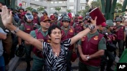 Una mujer ora, biblia en mano, frente a guardias bolivarianos, durante una protesta en Plaza Altamira, Caracas.