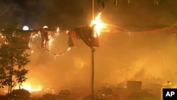 Foto yang dirilis oleh Eleven Media Group ini menggambarkan perkampungan perkemahan para pengunjuk rasa yang dibakar oleh pihak berwenang Burma untuk membubarkan mereka dari depan pertambangan tembaga Letpadaung dekat kota Monywa, Kamis pagi (29/11).