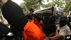 FILE - Police anti-terror unit Special Detachment 88 escort suspected militants before a press conference in Jakarta, Indonesia, May 17, 2019. 