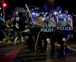 FILE - A man is detained after a standoff between protesters and police on August 18, 2014, during a protest for Michael Brown, who was killed by a police officer August 9 in Ferguson, Mo.