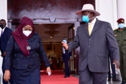 FILE - Uganda's President Yoweri Museveni, right, and Tanzania's President Samia Suluhu Hassan meet at the Statehouse in Entebbe, Uganda, in this handout picture taken and released on April 11, 2021, by Presidential Press Unit of Uganda.