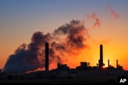 FILE - A coal-fired power plant is silhouetted against the morning sun in Glenrock, Wyoming, July 27, 2018. (AP Photo/J. David Ake, File)