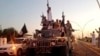 FILE - Fighters from the Islamic State group parade in a commandeered Iraqi security forces armored vehicle down a main road at the northern city of Mosul, Iraq, June 23, 2014.
