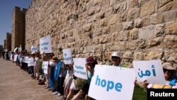 Sejumlah aktivis perempuan Israel, baik yang berasal dari etnis Yahudi maupun Arab, melakukan aksi unjuk rasa menyerukan perdamaian di luar tembok Kota Tua Yerusalem hari Rabu (19/5) (Foto: Reuters/Ronen Zvulun)