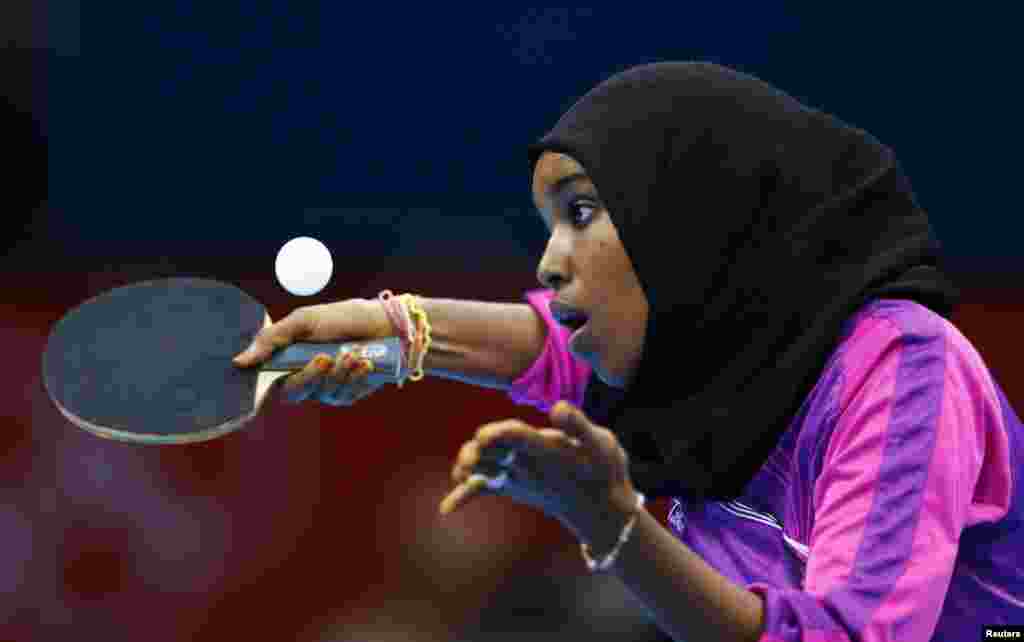 Atlet Djibouti Yasmin Hassan Farah melakukan dalam pertanidngan tenis meja melawan Caroline Kumahara dari Brazil di stadion ExCel.