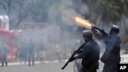 Polisi Brazil menembakkan peluru karet ke arah demonstran di kota Brasilia (15/6). Para pejabat kota di Brazil membatalkan rencana menaikkan tarip transportasi umum yang memicu demonstrasi anti pemerintah. 