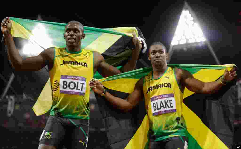 Usain Bolt celebrates winning gold alongside silver medalist Yohan Blake, both of Jamaica, following the men's 100-meter final.