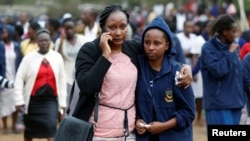 Orang tua siswa merangkul putrinya setelah insiden kebakaran yang membakar satu asrama di Sekolah Tinggi Moi Girls di Nairobi, Kenya, 2 September 2017. (REUTERS/Baz Ratner).