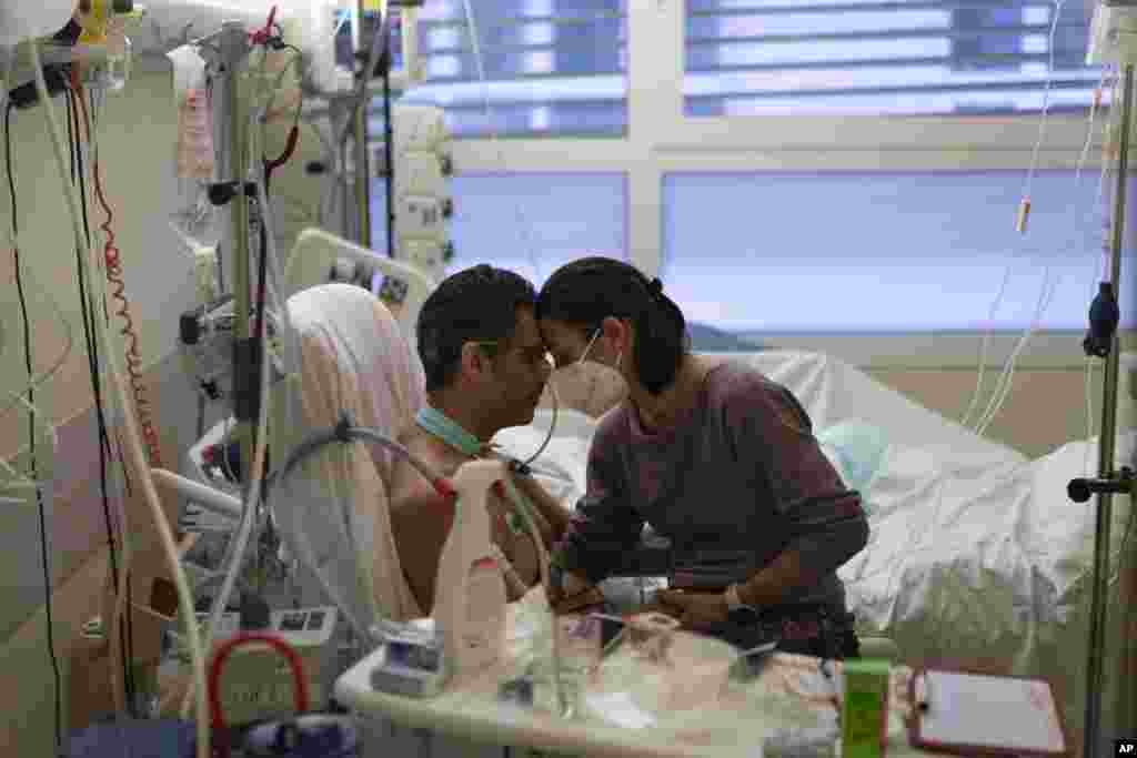 Amelie and Ludo Khayat hold each other during a visit at the COVID-19 intensive care unit of the la Timone hospital in Marseille, southern France. Ludo, 41, is recovering from spending 24 days in a coma and on a ventilator in a COVID-19 intensive care unit. Amelie began visiting her husband daily after he started to test negative for the virus.