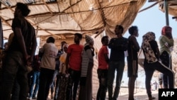 FILE - Eritrean refugees queue during a distribution of items organized the UNHCR at Mai Aini Refugee camp, in Ethiopia, Jan. 30, 2021.