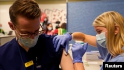 ourth-year medical student Anna Roesler administers the Pfizer-BioNTech coronavirus disease (COVID-19) vaccine at Indiana University Health, Methodist Hospital in Indianapolis, Indiana, U.S., December 16, 2020. REUTERS/Bryan Woolston/File Photo