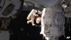 In this image from video made available by NASA, Russian cosmonaut Oleg Kononenko performs a spacewalk outside the International Space Station, Dec. 11, 2018.