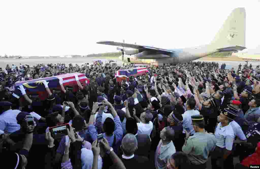 Coffins of Malaysian police who were killed on Saturday in Semporna in Sabah state, are carried after their arrival at an airport in Subang, outside Kuala Lumpur, March 4, 2013.