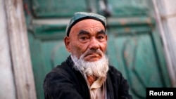 Seorang pria Uighur duduk di pasar jalanan di Kashgar, provinsi Xinjiang. (Foto: dok.)