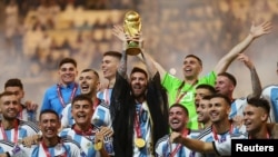 Mchezaji wa timu ya taifa ya Argentina, Lionel Messi akinyanyua kombe la dunia pamoja na wachezaji wenzake wakisherehekea kushinda Kombe la Dunia. Lusail Stadium, Lusail, Qatar - December 18, 2022 . Reuters.
