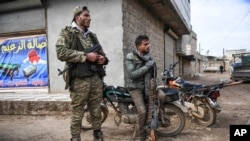 Syrian rebels sit outside Idlib, Syria, Saturday, Feb. 15, 2020. Syrian troops are waging an offensive in the last rebel stronghold. (AP Photo)