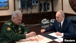 Presiden Rusia Vladimir Putin (kanan) dan Menteri Pertahanan Sergei Shoigu bertemu di St Petersburg pada 25 Desember 2023. (Foto: Sputnik/Alexei Danichev/Pool via Reuters)