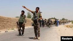 An Afghan National Army (ANA) soldier gestures as they arrive in Nad Ali district of Helmand province, southern Afghanistan, Aug. 10, 2016. 