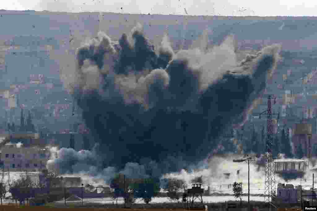 An explosion following an air-strike is seen in the Syrian town of Kobani from near the Mursitpinar border crossing on the Turkish-Syrian border, Oct. 28, 2014.