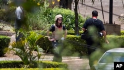Una extranjera no identificada involucrada en la investigación forense inspecciona la escena frente al centro comercial Westgate en Nairobi.