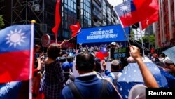 Partidarios del partido Kuomintang ondean banderas de Taiwán fuera del parlamento para mostrar su apoyo en Taipei, Taiwán, el 21 de junio de 2024.