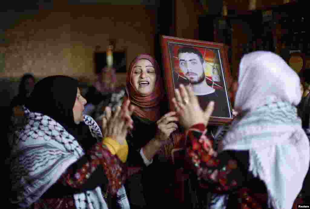 Relatives of Palestinian prisoner Rami Barbakh, who has been held by Israel since 1994, celebrate ahead of his expected release in Khan Younis, Gaza Strip, Dec. 30, 2013. 