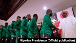 'Yan wasan Najeriya suna gaisawa tare da shugaban Najeriya Super Eagle, a lokacin da kofin duniya ya isa birnin Abuja
