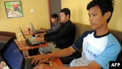 FILE - Cambodian men use the internet at a cofee shop in Phnom Penh.