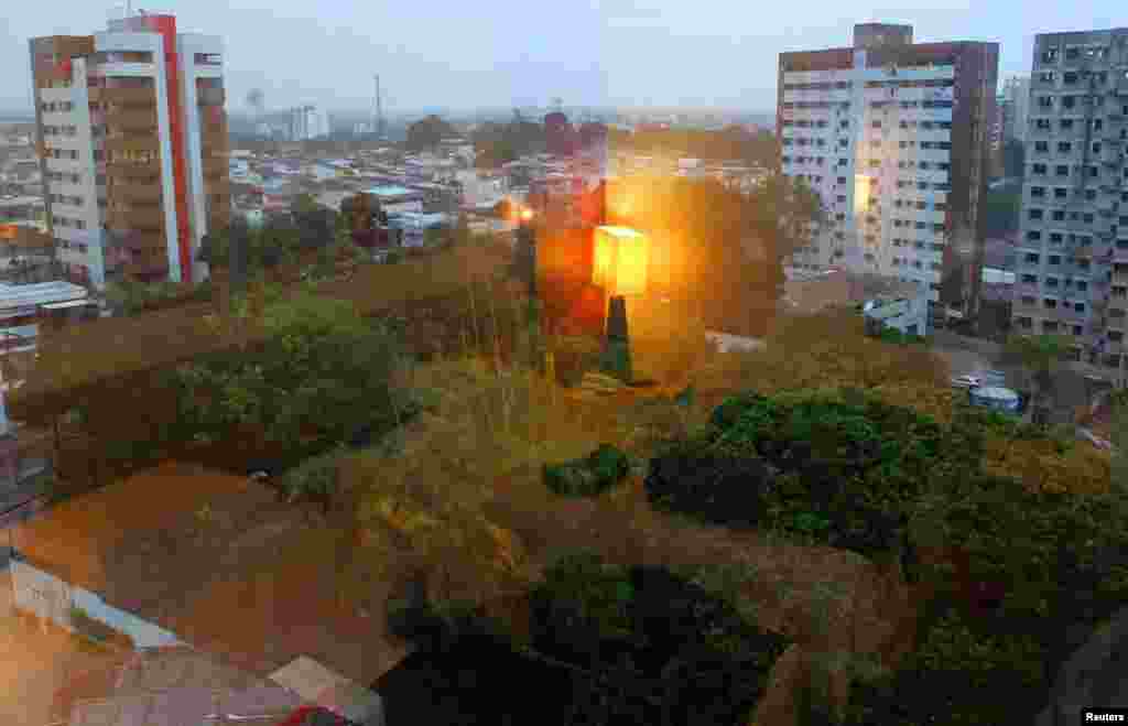 Lampu meja samping tempat tidur terpantul di jendela di kamar seorang fotografer Reuters pada sebuah hari hujan di Manaus, Brazil, 19 Juni 2014. 