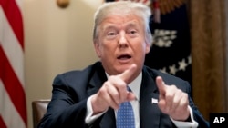 President Donald Trump points to members of the media as he speaks during a meeting with inner city pastors in the Cabinet Room of the White House in Washington, Aug. 1, 2018.