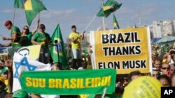 Simpatizantes del expresidente brasileño Jair Bolsonaro sostienen carteles en los que se lee: "Soy brasileño", y el que está a la derecha dice: "Brasil le agradece a Elon Musk". En Río de Janeiro, el 21 de abril de 2024.