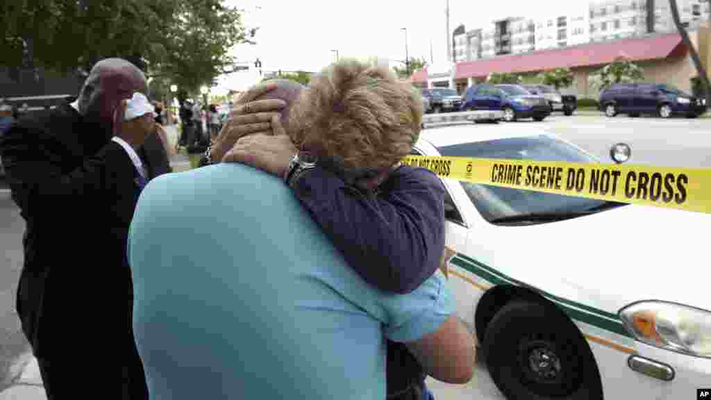 Terry DeCarlo, executive director of the LGBT Center of Central Florida, center, is comforted by Orlando City Commissioner Patty Sheehan, right, after a shooting at a nightclub in Orlando, Fla., June 12, 2016.