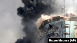 Gedung tempat kantor berita Associated Press dan sejumlah media lainnya di Kota Gaza ambruk setelah terkena serangan udara Israel, Sabtu, 15 Mei 2021. (Foto: Hatem Moussa/AP)