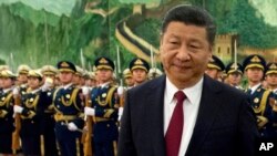 FILE - In this Tuesday, Jan. 9, 2018, file photo, Chinese President Xi Jinping reviews a Chinese honor guard during a welcome ceremony for a visiting dignitary at the Great Hall of the People in Beijing.