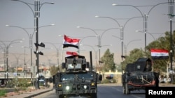 FILE - Iraqi security forces advance in military vehicles in Kirkuk, Iraq, Oct. 16, 2017.
