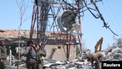 Pejuang dari Kelompok Perlindungan Warga Kurdi (YPG) memeriksa kerusakan markas besar mereka pasca serangan udara pesawat Turki di Mount Karachok dekat Malikiya, Suriah, 25 April 2017. (REUTERS/ Rodi Said).