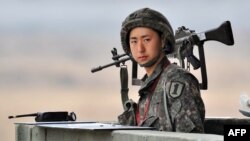 South Korean soldier stands on a military guard post near the demilitarized zone (DMZ) dividing the two Koreas in the border city of Paju on April 5, 2013. 