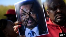 FILE - People protest Cameroon's President Paul Biya on Pennsylvania Avenue near the White House, Oct. 22, 2018 in Washington. In Cameroon, Security forces have been cracking down on street rallies protesting the October 7 re-election of President Paul Biya. 