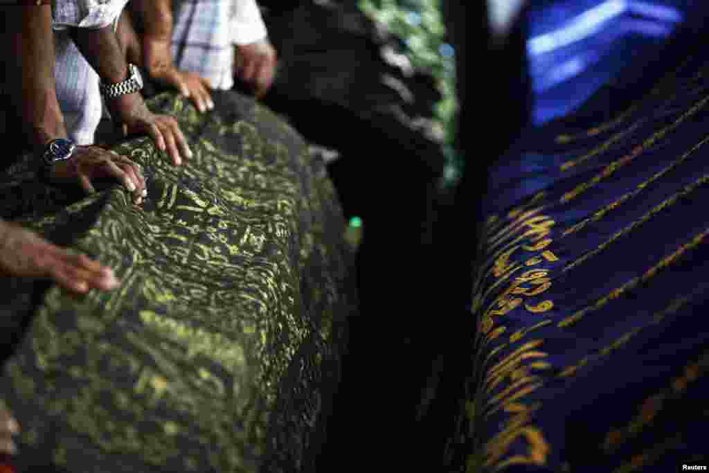 People prepare to pray around the coffins of victims of a fire during their funeral at Yaeway cemetery, Rangoon, Burma, April 2, 2013.