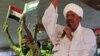 Supporters wave Sudanese flags as Sudanese President Omar al-Bashir addresses supporters during a rally at the ruling National Congress Party headquarters in Khartoum, Sudan, April 18, 2012.