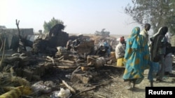 People return to the site after a bombing attack of an internally displaced persons camp in Rann, Nigeria Jan. 17, 2017.