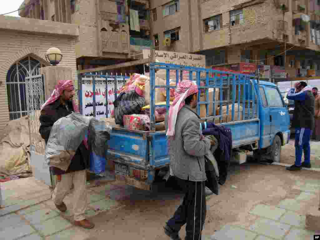 Civilians load their belongings as they leave their homes after clashes between the Iraqi army and al-Qaida fighters in Fallujah, Jan. 5, 2014.